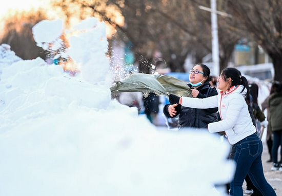 11月13日，在库伦旗红旗小学，教师和学生家长在清理积雪。新华社记者 连振 摄