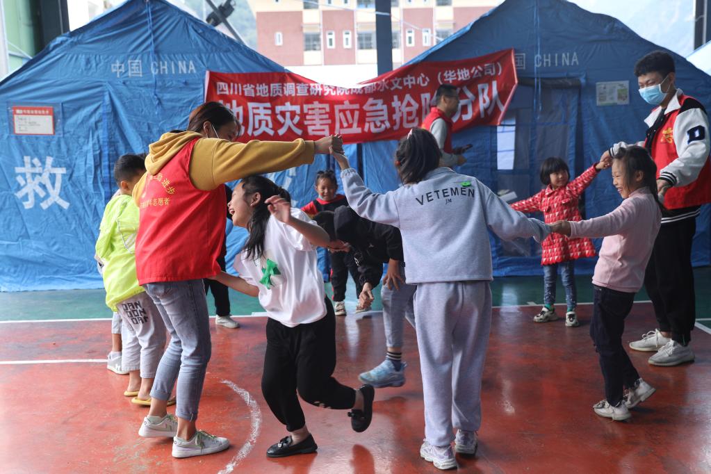 9日，在安置点“青青儿童乐园”里，志愿者老师正陪孩子们做游戏。新华社记者 刘琼 摄